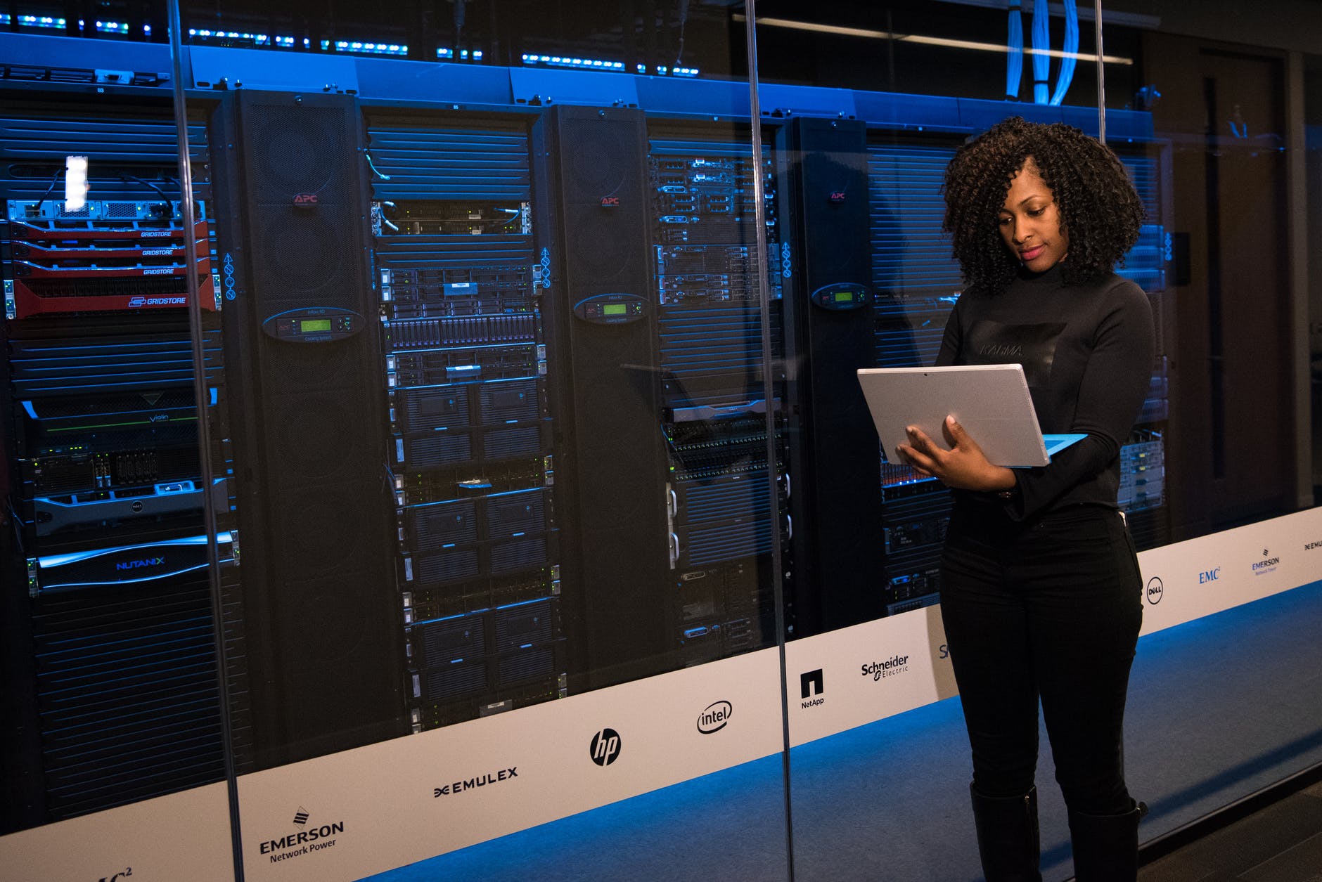 Ciência de Dados - mulher segurando computador em frente a equipamento de big data