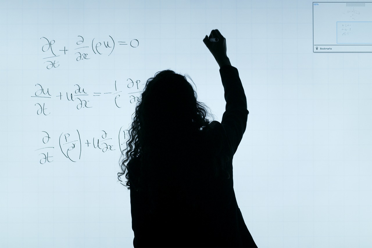 engenharia-de-producao-ead - mulher escreve fórmula matemática em uma lousa branca